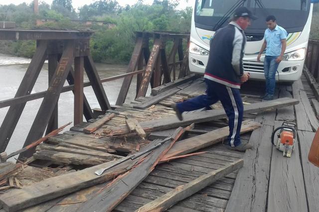 Moradores e motoristas fazem o conserto das madeiras da ponte das Tunas, entre Restinga Seca e Formigueiro.