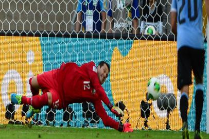 Brazil's goalkeeper Julio Cesar (R) prevents Uruguay's forward Diego Forlan from scoring a penalty during their FIFA Confederations Cup Brazil 2013 semifinal football match, at the Mineirao Stadium in Belo Horizonte on June 26, 2013.   AFP PHOTO / CHRISTOPHE SIMON