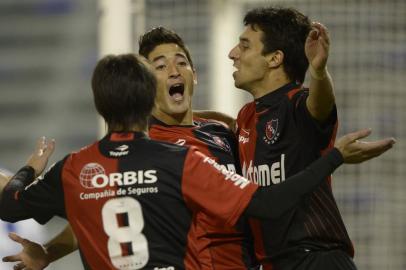 Newell's Old Boys' defender Milton Casco (C) celebrates with teammate forward Ignacio Scocco (R) and midfielder Pablo Perez after scoring against Velez Sarsfield during their Copa Libertadores 2013 round before the quarterfinals second leg football match at Jose Amalfitani stadium in Buenos Aires, Argentina, on May 15, 2013. AFP PHOTO / Juan Mabromata