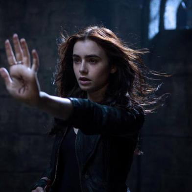 OS INSTRUMENTOS MORTAIS _ Cidade dos Ossos. Com Lily Collins, 130min, 12 anos. Quando a mãe da adolescente Clary Fray (Lily Collins, foto) desaparece, ela descobre ser descendente de uma linhagem de caçadores que protege o nosso mundo de demônios. A partir de então, Clary une suas forças às de outros jovens como ela em uma perigosa jornada em uma Nova York alternativa.