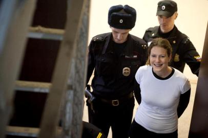 A handout picture taken on November 19, 2013 and released by Greenpeace International shows Greenpeace International activist, one of the "Arctic 30," Ana Paula Alminhana Maciel from Brazil (R), smiling while being escorted by police officers in a court in Russia's second city of Saint Petersburg. A Russian court released on bail the Brazilian Greenpeace activist, the first non-Russian to be set free from the so-called Arctic 30 detained for a protest against oil drilling, the group said today. AFP PHOTO / GREENPEACE DMITRI SHAROMOV
---EDITORS NOTE-- IMAGE AVAILABLE FOR DOWNLOAD BY EXTERNAL MEDIA FOR 14 DAYS AFTER RELEASE -- RESTRICTED TO EDITORIAL USE - MANDATORY CREDIT "AFP PHOTO / GREENPEACE /DMITRI SHAROMOV" - NO MARKETING NO ADVERTISING CAMPAIGNS - DISTRIBUTED AS A SERVICE TO CLIENTS --  NO ARCHIVE -----