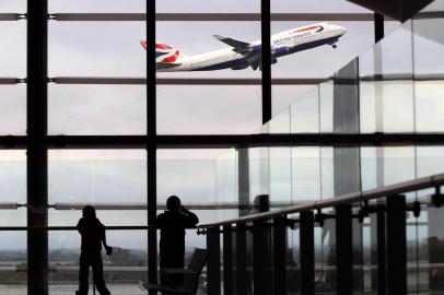 Passageiros no aeroporto de Heathrow, em Londres, observam decolagem de Boeing 747 de  British Airways. A British Airways passenger jet takes off from Terminal 5, at Heathrow Airport, west of London, on October 29, 2010.  British Airways on Friday posted net profits of 107 millions pounds for the first six months of the group's financial year, its first interim profit for two years, as revenues rose and non-fuel costs fell.  The impressive result, equivalent to 122 millions euros or 170 million dollars, compared with a net loss of 217 million pounds in the six months to September 2009, the airline said in a results statement.           AFP PHOTO/BEN STANSALL