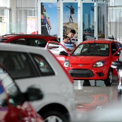  CAXIAS DO SUL, RS, BRASIL, 30/12/2013 - Últimos dias de vendas de automóveis com IPI reduzido movimentam concessionárias em Caxias do Sul. O programador Grégori Machado da Silva, 26 anos, aproveitou a tarde do dia 30 de dezembro para comprar um carro zero com alíquotas menores do imposto. Vendedora da Florauto, Viviane Fragoso deu as últimas instruções a Grégori sobre o Ka que ele adquiria.Indexador: JONAS RAMOS                     