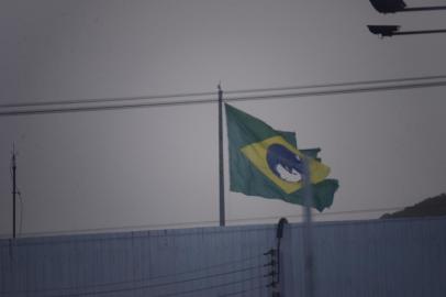  

ITAJAI,SC,BRASIL, 18/02/2014: Bandeira do Brasil rasgada no topo de um mastro em um posto de gasolina as margens da rodovia Jorge Lacerda