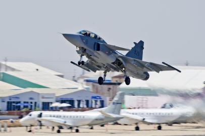 Gripen takes off with two civilian aircaraft in the background at Aero India.