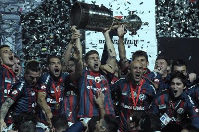 TOPSHOTSArgentina's San Lorenzo players holds up the trophy after winning the Copa Libertadores 2014 final second leg football match against to Paraguay's Nacional at Pedro Bidegain stadium in Buenos Aires, Argentina, on August 13, 2014.  AFP PHOTO / ALEJANDRO PAGNI