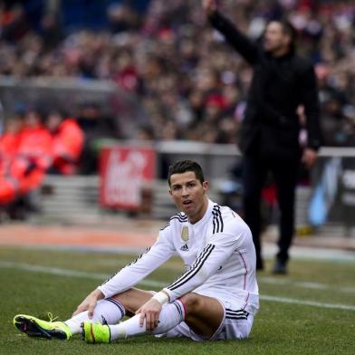 Real Madrid's Portuguese forward Cristiano Ronaldo reacts as he sits on the pitch during the Spanish league football match Club Atletico de Madrid vs Real Madrid CF at the Vicente Calderon stadium in Madrid on February 7, 2015.   AFP PHOTO/ DANI POZO