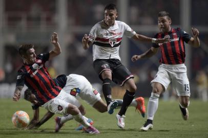 Brazil's Sao Paulo Ricardo Centurion (C) vies for the ball with Argentina's San Lorenzo defender Julio Buffarini (L) and midfielder Hector Villalba during their Copa Libertadores 2015 group 2 football match at Pedro Bidegain stadium in Buenos Aires, Argentina, on April 1, 2015. AFP PHOTO / JUAN MABROMATA