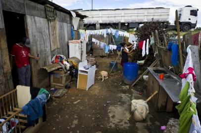  PORTO ALEGRE, RS, BRASIL, 21-03-2013: A desempregada Fabiana Nunes da Silva, 32 anos,  recolhe roupas no varal ao lado da casa de emergencia onde mora desde 2007, na Ilha do Pavao, no bairro Arquipelago, as margens da BR-290. Ela vive com os oito filhos, um deles com 30 dias, e o neto, de 6 meses, na moradia doada pelo Demhab. A renda mensal da familia e de 430 reais, o que garante 1,5 real por dia para cada um. Recentemente, o governo federal anunciou medidas para acabar com a pobreza extrema no Brasil atraves do programa Bolsa Familia. No entanto, ainda ha familias necessitadas que nao recebem o beneficio e, outras, em que apenas esse recurso parece nao solucionar a situacao. (Foto: Mateus Bruxel / Diario Gaucho) EMBARGADO PARA MATÉRIA ESPECIAL