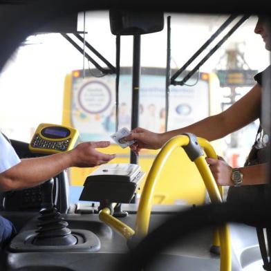  Caderno sobre mobilidade - Usuário de ônibus pagando passagem com dinheiro em Joinville. Na foto o motorista Angelo Cunha e a passageira Marlusse Aline Quintino.