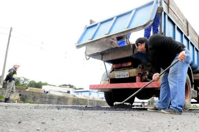  CAXIAS DO SUL, RS, BRASIL, 23/07/2015. O empresário Vicente Slomp (de blusa preta), 54 anos, cansou de ver amigos e familiares estragando carros e prejudicando a rotina com os buracos espalhados pela ERS-122, em Caxias do Sul. Pela segunda vez neste ano, ele reuniu sua equipe da Slomp Concreteira, que fica nas margens da rodovia, e percorreu alguns trechos mais críticos da rodovia para tapar buracos. Na foto, tampando buracos no KM 65, no retorno de acesso ao bairro Forqueta. (Porthus Junior/Pioneiro)