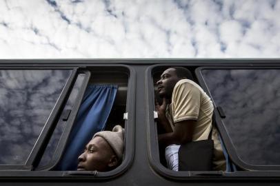 MINAS GERAIS, BRASIL, 31-05-2015: Haitianos na janela durante viagem em ônibus da empresa Trans Brasil. O coletivo partiu de Rio Branco (AC) para São Paulo com grupo de imigrantes. A viagem durou três dias. (Foto: Mateus Bruxel / Agencia RBS)