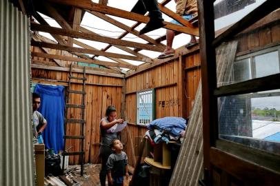  NOVO HAMBURGO-RS-BRASIL- 18/09/2015-  Chuva de granizo deixa mais de 500 casas destelhadas em Novo Hamburgo, bairro Santo Afonso. Casa de Gisele dos Santos, ficou com o telhado destruído, teve a ajuda de familiares para consertar a cobertura.  FOTO FERNANDO GOMES/ZERO HORA.