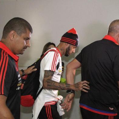 Atacante Paulinho é escolta por seguranças em desembarque do Flamengo no Rio.