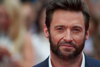 Australian actor Hugh Jackman poses for pictures on the red carpet as he arrives for the UK premier of the film 'The Wolverine' in London on July 16, 2013.