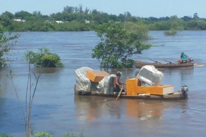 Moradores de Quaraí retiram mobília de suas casas por barco devido a cheia do Rio Uruguai