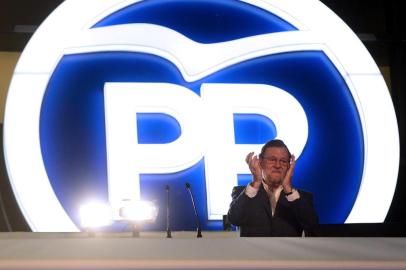 Spanish Prime Minister and Popular Party (PP) leader and candidate for general election, Mariano Rajoy applauds at the partys headquarters balcony after the results of Spains general elections in Madrid on December 20, 2015. Spains ruling conservative Popular Party won the most seats in parliament in a general election today but lost its absolute majority, partial results showed with over 80 percent of votes counted. AFP PHOTO / JOSE JORDAN


