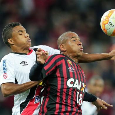 Walter from Brazil's Atletico Paranaense vies for the ball with Arnaldo (L) from Brazil's Joinvilleduring their Sudamericana Cup football match at the Arena da Baixada stadium in Curitiba on August 27, 2015.   AFP PHOTO / HEULER ANDREY