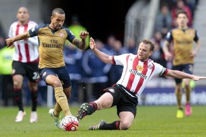 Arsenals English midfielder Theo Walcott (2nd L) is challenged by Sunderlands English midfielder Lee Cattermole (2nd R) during the English Premier League football match between Sunderland and Arsenal at the Stadium of Light in Sunderland, northeast England on April 24, 2016. 