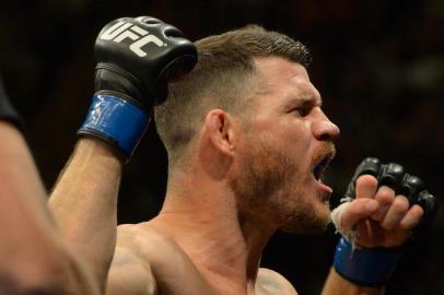 INGLEWOOD, CA - JUNE 04: Michael Bisping raises his arms to the crowd as he enters the cage for his middleweight championship bout at UFC 199 at The Forum on June 4, 2016 in Inglewood, California.   Jayne Kamin-Oncea/Getty Images/AFP