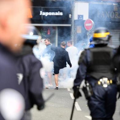 French policemen fire tear gas to disperse supporters gathering outside a bar in Lille, northern France, on June 15, 2016, on the sideline of the Euro 2016 European football championships.  / AFP PHOTO / LEON NEAL