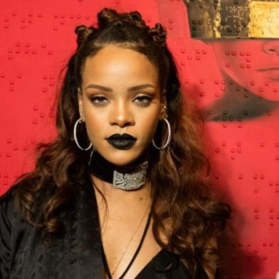 a cantora rihanna em frente ao pôster de seu novo disco, anti