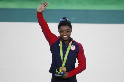  US gymnast Simone Biles celebrates with her gold medal on the podium after the womens individual all-around final of the Artistic Gymnastics at the Olympic Arena during the Rio 2016 Olympic Games in Rio de Janeiro on August 11, 2016. US gymnast Simone Biles won the event ahead of her compatiot Alexandra Raisman and Russias Aliya Mustafina.Thomas COEX / AFPEditoria: SPOLocal: Rio de JaneiroIndexador: THOMAS COEXSecao: gymnasticsFonte: AFPFotógrafo: STF