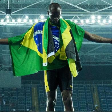 Jamaica's Usain Bolt poses with the Jamaican flag after Team Jamaica won the Men's 4x100m Relay Final during the athletics event at the Rio 2016 Olympic Games at the Olympic Stadium in Rio de Janeiro on August 19, 2016. / AFP PHOTO / LEON NEAL