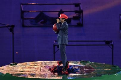 Japanese Prime Minister Shinzo Abe, dressed as Super Mario, holds a red ball during the closing ceremony of the Rio 2016 Olympic Games at the Maracana stadium in Rio de Janeiro on August 21, 2016. PHILIPPE LOPEZ / AFP