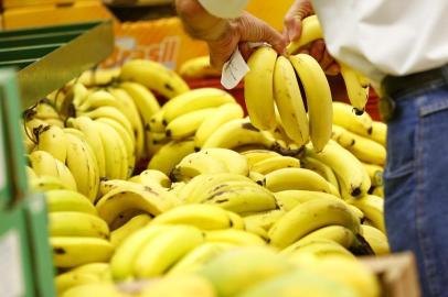  PORTO ALEGRE, RS, BRASIL, 12-03-2014: Cliente escolhe bananas em um hipermercado na zona sul de Porto Alegre. A cesta básica da Capital está R$ 4,50 mais barata em relação ao valor de janeiro e a fruta é um dos itens que teve variação considerável. (Foto: Mateus Bruxel / Diário Gaúcho)