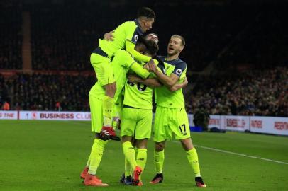 Liverpools English midfielder Adam Lallana celebrates scoring his teams third goal with Liverpools Brazilian midfielder Roberto Firmino (L) and Liverpools Estonian defender Ragnar Klavan (R) during the English Premier League football match between Middlesbrough and Liverpool at Riverside Stadium in Middlesbrough, northeast England on December 14, 2016. Lindsey PARNABY / AFP