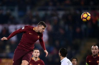 Roma's Bosnian-Herzegovinan forward Edin Dzeko (L) heads the ball during the italian Serie A football match between Roma and Chievo Verona  on December 22, 2016 at the Olympic Stadium in Rome. / AFP PHOTO / FILIPPO MONTEFORTE