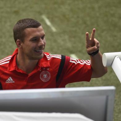 Germanys forward Lukas Podolski does the victory sign before the semi-final football match between Brazil and Germany at The Mineirao Stadium in Belo Horizonte during the 2014 FIFA World Cup on July 8, 2014.  AFP PHOTO / ODD ANDERSEN