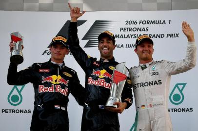 Second-placed Red Bull Racing's Belgian-Dutch driver Max Verstappen (L), champion Red Bull Racing's Australian driver Daniel Ricciardo (C) and third-placed Mercedes AMG Petronas F1 Team's German driver Nico Rosberg (R) celebrate on the podium during the Formula One Malaysian Grand Prix in Sepang on October 2, 2016. / AFP PHOTO / MANAN VATSYAYANA