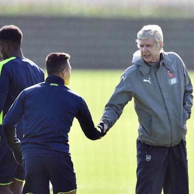 Arsenals French manager Arsene Wenger (R) shakes hands with Chilean striker Alexis Sánchez (L) during a training session ahead of their UEFA Champions League round of 16 second leg football match against Bayern Munich at Arsenals London Colney training ground on March 6, 2017.  / AFP PHOTO / GLYN KIRK