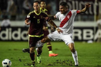 Venezuelas midfielder Alejandro Guerra (L) vies for the ball with Perus forward Paolo Guerrero  during their 2018 FIFA World Cup qualifier football match in Maturin, Venezuela, on March 23, 2017. / AFP PHOTO / JUAN BARRETO