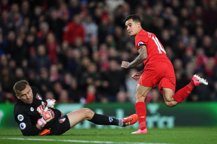 Liverpools Brazilian midfielder Philippe Coutinho (R) watches hsi shot beat Bournemouths Polish goalkeeper Artur Boruc as Liverpool make the score 1-1 during the English Premier League football match between Liverpool and Bournemouth at Anfield in Liverpool, north west England on April 5, 2017. / AFP PHOTO / Paul ELLIS / RESTRICTED TO EDITORIAL USE. No use with unauthorized audio, video, data, fixture lists, club/league logos or live services. Online in-match use limited to 75 images, no video emulation. No use in betting, games or single club/league/player publications.  / 