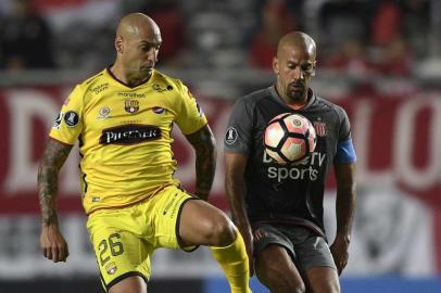 Argentinas Estudiantes de La Plata President and midfielder Juan Veron (R) vies for the ball with Ecuadors Barcelona forward Ariel Nahuelpan during their Copa Libertadores group 1 football match at Ciudad de La Plata stadium in La Plata, Buenos Aires on April 11, 2017. / AFP PHOTO / JUAN MABROMATA