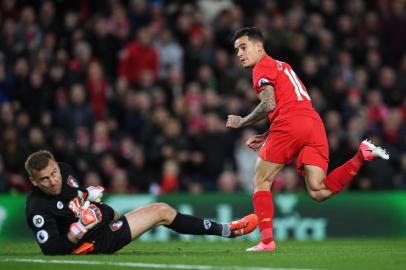 Liverpools Brazilian midfielder Philippe Coutinho (R) watches hsi shot beat Bournemouths Polish goalkeeper Artur Boruc as Liverpool make the score 1-1 during the English Premier League football match between Liverpool and Bournemouth at Anfield in Liverpool, north west England on April 5, 2017. / AFP PHOTO / Paul ELLIS / RESTRICTED TO EDITORIAL USE. No use with unauthorized audio, video, data, fixture lists, club/league logos or live services. Online in-match use limited to 75 images, no video emulation. No use in betting, games or single club/league/player publications.  / 