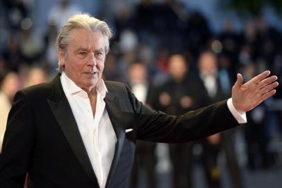 (FILES) This file photo taken on May 25, 2013 shows French actor Alain Delon arriving to attend the screening of the new restored version of the film "Plein Soleil" presented in Cannes Classics at the 66th edition of the Cannes Film Festival in Cannes.=Delon, the French star dubbed one of "the best looking actors of all time", declared on May 9, 2017 that he was calling time on his career. The 81-year-old screen legend -- who is credited with inventing the character of the cerebral hitman, which has since become a Hollywood standard -- told AFP that he would do one last film and a play before retiring. / AFP PHOTO / ANNE-CHRISTINE POUJOULAT