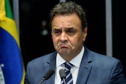 (FILES) This file photo taken on August 30, 2016 shows opposition leader Senator Aecio Neves speaks during the senate impeachment trial of Brazilian suspended President Dilma Rousseff at the National Congress in Brasilia. Brazils President Michel Temer reeled on May 18, 2017 from a report that he authorized payment of hush money to a jailed politician in a scandal threatening to plunge Latin Americas biggest country into political meltdown. In another blow for the veteran leader of the center-right PMDB party, his key ally Senator Aecio Neves from the PSDB party was targeted by anti-graft police early Thursday. / AFP PHOTO / ANDRESSA ANHOLETE