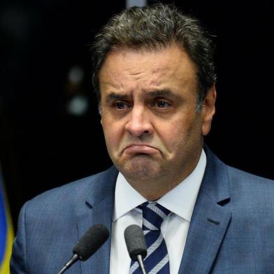 (FILES) This file photo taken on August 30, 2016 shows opposition leader Senator Aecio Neves speaks during the senate impeachment trial of Brazilian suspended President Dilma Rousseff at the National Congress in Brasilia. Brazil's President Michel Temer reeled on May 18, 2017 from a report that he authorized payment of hush money to a jailed politician in a scandal threatening to plunge Latin America's biggest country into political meltdown. In another blow for the veteran leader of the center-right PMDB party, his key ally Senator Aecio Neves from the PSDB party was targeted by anti-graft police early Thursday. / AFP PHOTO / ANDRESSA ANHOLETE