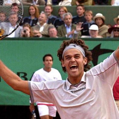 Brazilian Gustavo Kuerten celebrates after winning the men's singles final against Spanish Alex Corretja (back) 10 June 2001, at the French Tennis Open in Roland Garros, Paris. Top seed and defending champion Kuerten won the title for the third time, defeating 13th seed Alex Corretja 6-7 (3/7), 7/5, 6-2, 6-0.        AFP PHOTO/PASCAL GEORGE Fonte: AFP Fotógrafo: PASCAL GEORGE