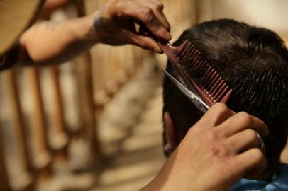 PORTO ALEGRE, RS, BRASIL, 15/09/2015-   O Cabelereiro Jordan Maestri Soares Fialho, 19 anos, corta o cabelo de Régis Lima no Piquete Querência do Peão. (FOTO: CARLOS MACEDO/ AGENCIA RBS)