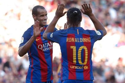 Former Barcelona's Brazilian forward Ronaldinho (R) and former Barcelona's Brazilian midfielder Rivaldo celebrate during a charity football match between Barcelona Legends vs Manchester United Legends at the Camp Nou stadium in Barcelona on June 30, 2017. / AFP PHOTO / PAU BARRENA