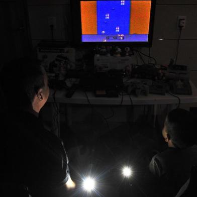  Santa Maria, , Brasil, 22/04/2017.Videogame Atari, entre outros, estão sendo relançados. Tem quem goste da versão atual e quem prefira comprar os clássicos dos anos 1980.Na foto: Deivid Gomes e o filho Nicolas, em casa jogando Atari.Indexador: GERMANO RORATO