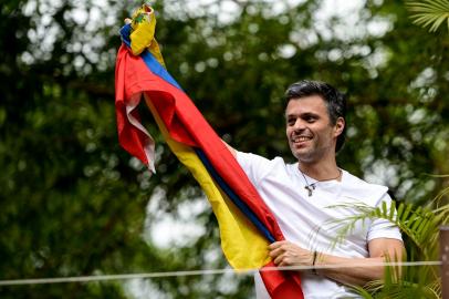 Venezuelan opposition leader Leopoldo Lopez displaying a Venezuelan national flag, greets supporters gathering outside his house in Caracas, after he was released from prison and placed under house arrest for health reasons, on July 8, 2017. Venezuela's Supreme Court confirmed on its Twitter account it had ordered Lopez to be moved to house arrest, calling it a "humanitarian measure" granted on July 7 by the court's president Maikel Moreno. "Leopoldo Lopez is at his home in Caracas with (wife) Lilian and his children," Lopez's Spanish lawyer Javier Cremades said in Madrid. "He is not yet free but under house arrest. He was released at dawn." 