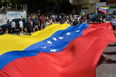 People gather in Caracas on July 16, 2017 during an opposition-organized vote to measure public support for President Nicolas Maduro's plan to rewrite the constitution.Authorities have refused to greenlight the vote that has been presented as an act of civil disobedience and supporters of Maduro are boycotting it. Protests against Maduro since April 1 have brought thousands to the streets demanding elections, but has also left 95 people dead, according to an official toll.  / AFP PHOTO / FEDERICO PARRA