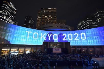 A projection that reads "Tokyo 2020" is seen during a ceremony marking three years to go before the start of the Tokyo 2020 Olympic games at the Tokyo Metropolitan Assembly Building on July 24, 2017.Japan marked three years before the 2020 Tokyo Olympics on July 24 with celebration and fanfare -- even as organisers struggle to contain soaring costs and restore credibility. / AFP PHOTO / Kazuhiro NOGI