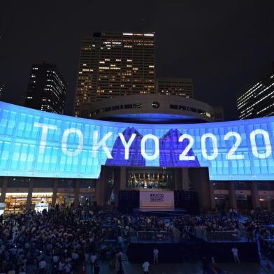 A projection that reads "Tokyo 2020" is seen during a ceremony marking three years to go before the start of the Tokyo 2020 Olympic games at the Tokyo Metropolitan Assembly Building on July 24, 2017.Japan marked three years before the 2020 Tokyo Olympics on July 24 with celebration and fanfare -- even as organisers struggle to contain soaring costs and restore credibility. / AFP PHOTO / Kazuhiro NOGI